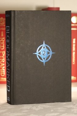 A black hardcover book with a blue star in the middle containing the number two.
